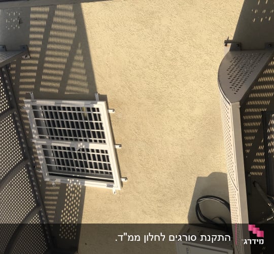 סורג ברזל ישר מותקן על חלון בקיר חיצוני של בית